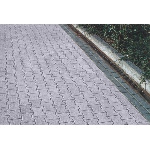 Pavés autobloquants en béton double T avec bordure, pierres de pavage grises posées.