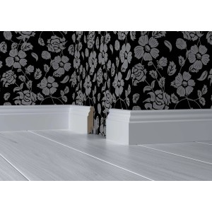 Plinthe blanche White&Black Style (70x18x2500mm) devant un mur à motifs floraux sur un plancher en bois clair.