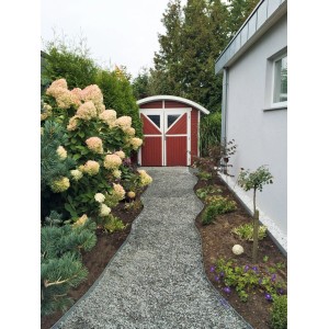Allée de jardin avec stabilisateur de gravier ACO Self® eco S menant à un cabanon rouge.