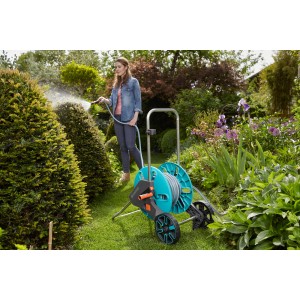 Gardena AquaRoll M Set: Donna che annaffia il giardino con avvolgitubo. Irrigazione pratica del giardino.