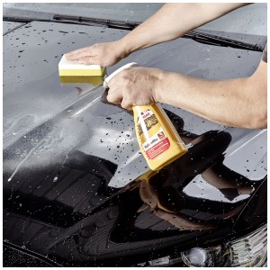 Application de Sonax High Speed Wax sur une peinture de voiture avec une éponge.