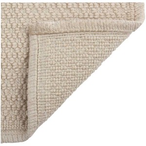 Tappeto bagno beige Spirella Perla (50x80 cm) in cotone con texture a nodi e frange.