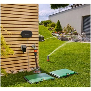Computer per irrigazione Gardena smart Irrigation Control 24 V in giardino con irrigatori in azione.