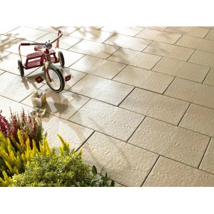 Posa di lastre per terrazza Kann Sincera color crema 60x40 cm con giocattoli per bambini e piante.