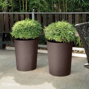 Deux pots de fleurs marron Deroma Millennium (Ø 43,5 cm) avec des plantes sur une terrasse.