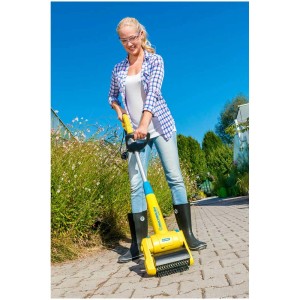 Femme utilisant la brosse de surface Gloria MultiBrush SpeedControl pour nettoyer les pavés.