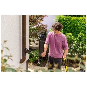 Uomo pulisce la grondaia con il set di pulizia tubi Kärcher PC 15 con idropulitrice.