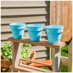 Tre vasi da fiori in plastica blu sulla stazione da giardino per bambini KidKraft Greenville.