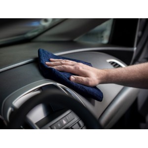 Main nettoyant le tableau de bord de voiture avec un chiffon microfibre bleu (lot de 3) pour l'entretien auto.