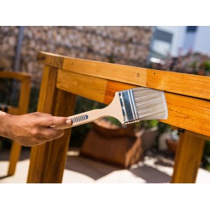 Pennello per facciate LUX 50mm con serbatoio di vernice che applica la vernice su un tavolo di legno all'aperto.