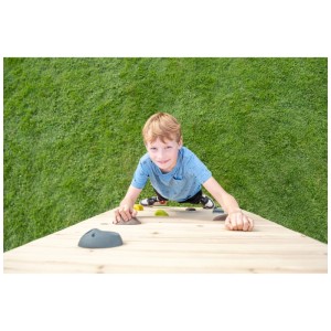 Bambino si arrampica sulla parete da arrampicata in legno Exit Toys GetSet con prese grigie e verdi.