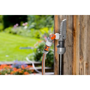 Connecteur d'eau Gardena avec tuyau fixé à une cabane de jardin. Sortie d'eau pour systèmes d'arrosage.
