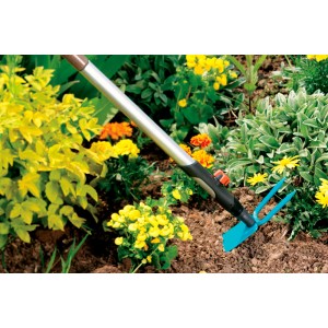 Houe de jardin Gardena combisystem avec manche dans le parterre de fleurs, largeur de travail 7,5 cm.