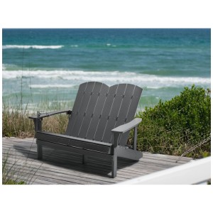 Banc de jardin Beliani Adirondack gris foncé en bois composite sur une terrasse en bois près de la mer.