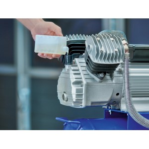 Huile pour outils pneumatiques versée dans un compresseur.