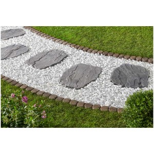 Pas japonais Nativa gris (56x42x4 cm) posés dans un jardin sur des pierres blanches.