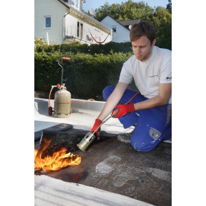 Homme travaillant avec le chalumeau Rothenberger RoMini (outil de soudure) sur un toit.