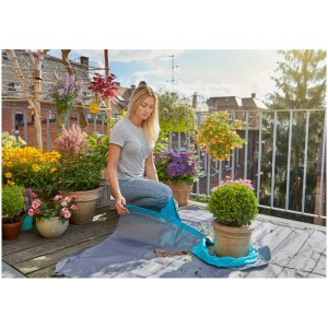 Tapis de taille Gardena en utilisation : Femme taillant un buis sur un balcon. Aide à la coupe pratique.