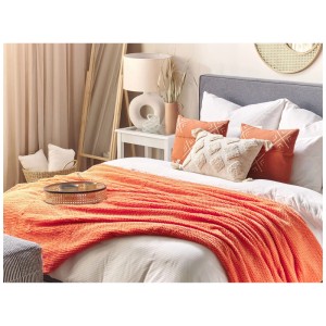 Coperta arancione Beliani Bjas (200x220 cm) su un letto con cuscini.