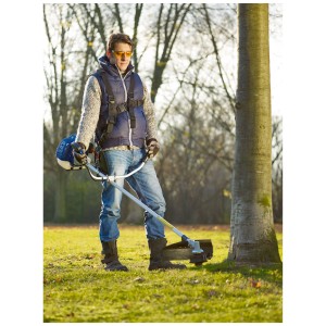 Homme portant des lunettes de protection jaunes LUX 250 coupant la pelouse dans le jardin.