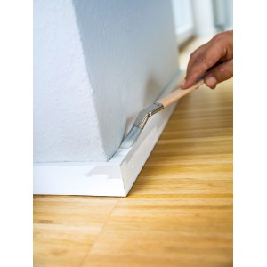 Applicazione: Pennello piatto curvo LUX 20 mm che dipinge un battiscopa.