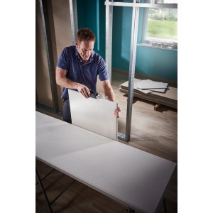 Homme utilisant un rabot de bloc wolfcraft sur une plaque de plâtre. Rabot avec large surface de râpe.