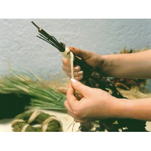 Mains attachant un bouquet avec du raphia naturel. Raphia de couleur naturelle pour la décoration et le jardinage.
