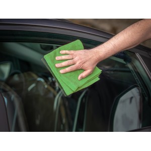 Main essuyant une vitre de voiture avec un chiffon en microfibre vert (lot de 3) pour l'entretien automobile.