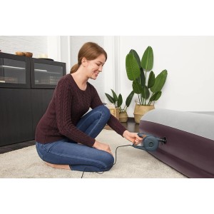 Donna che utilizza la pompa ad aria elettrica Bestway Powergrip per gonfiare un materasso ad aria.
