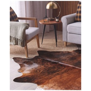 Braun gemusterter Kuhfell-Teppich Nasqu aus Echtleder (2-3 m²) im Wohnzimmer.