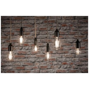 Mehrere Paulmann E14 LED Kerzenlampen mit klarem Glas und warmweissem Licht vor einer Backsteinwand.