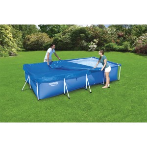 Piscine rectangulaire bleue avec bâche Flowclear (410x226cm) installée par deux personnes dans le jardin.