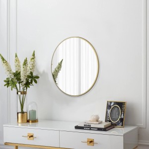 Specchio di design rotondo DSK Picasso, Ø 50 cm, con cornice dorata su parete bianca.
