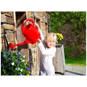 Fille arrosant des fleurs avec un arrosoir d'intérieur rouge (4 l).