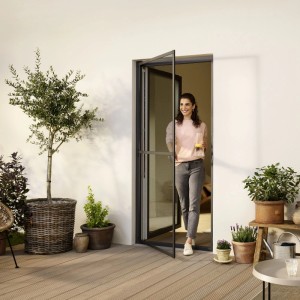 Porta zanzariera tesa® con telaio in alluminio antracite, donna che attraversa. Protezione ottimale dagli insetti.
