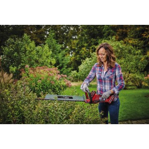 Femme taillant une haie avec le taille-haie sans fil Einhell Power X-Change GE-CH 36/61 Li-Solo.