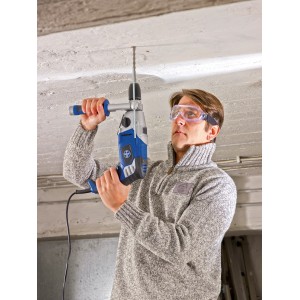 Homme perçant le plafond avec une perceuse à percussion et des lunettes de protection LUX avec bandeau.