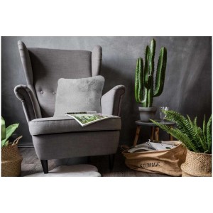 Coussin Coste en polyester gris 40x40 cm sur fauteuil, ambiance cosy.