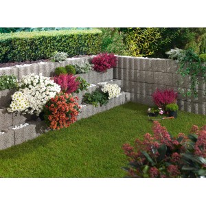 Blocchi di sostegno Wellino grigi piantati come pendio a gradoni in giardino.