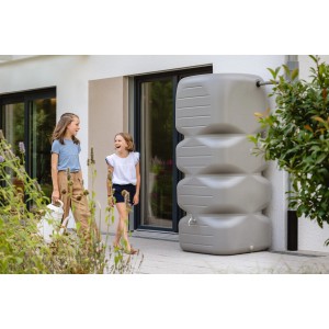 Serbatoio da giardino Garantia Cubus 1000 l in grigio cemento davanti a muro di casa con bambini.