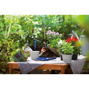 Voile de protection LUX sur table avec plantes et outils de jardinage. Protection contre la saleté lors du jardinage.