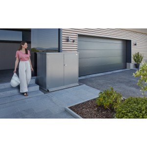 Biohort Alex Duo box à poubelles en gris quartz métallisé devant la maison avec femme. Pour 2 poubelles.