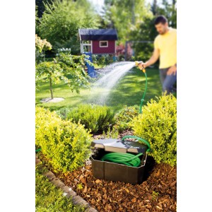 Heissner Garden Power Box in giardino con tubo e persona che annaffia. Distributore di corrente per pompe per laghetti.