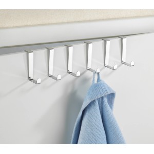 Set da 6 ganci appendiabiti Wenko in acciaio inox su porta con asciugamano blu.