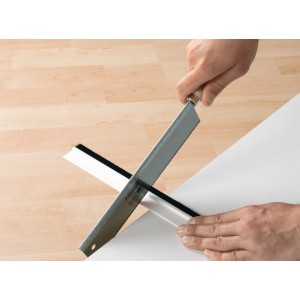 Coupe à la scie du joint de porte Tesamoll blanc pour sols textiles.