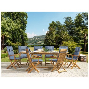 Salon de jardin Beliani Maui 9 p.: table et 8 chaises en acacia avec coussins bleus sur terrasse.