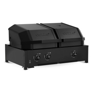 Barbecue a gas nero Cozze Quattro 900 con quattro zone di cottura, inclusi i pomelli di controllo.