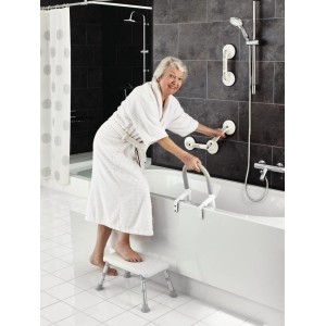 Femme utilisant le marchepied de bain Ridder blanc réglable en hauteur pour entrer dans la baignoire.