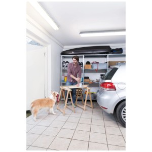 Homme travaillant dans un garage avec un luminaire étanche LED Osram. Lumière blanche froide et vive.