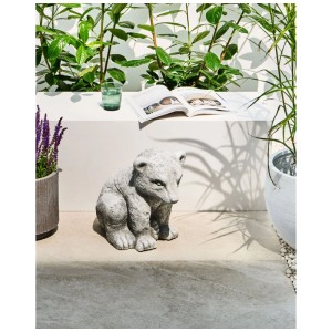 Graue sitzende Bärenfigur aus Magnesiumoxid als Gartendekoration auf einer Terrasse.